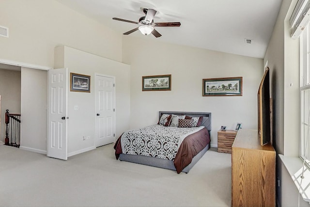 carpeted bedroom with visible vents, vaulted ceiling, and a ceiling fan