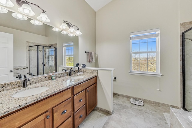 bathroom with a stall shower, a sink, and a healthy amount of sunlight