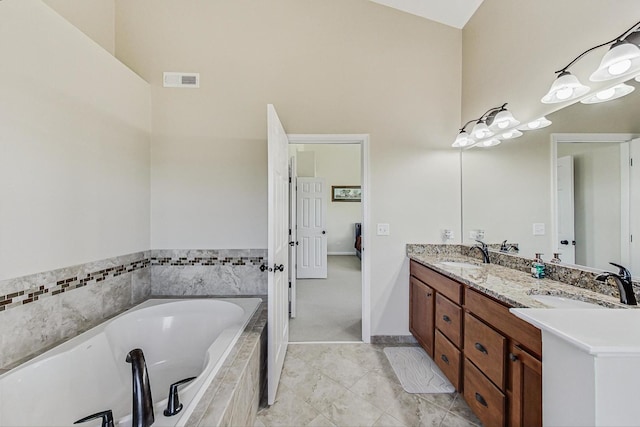 full bath featuring double vanity, a garden tub, visible vents, and a sink