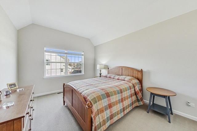 bedroom featuring lofted ceiling, baseboards, and light colored carpet