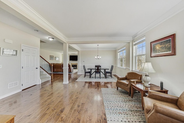 sitting room with visible vents, baseboards, stairs, ornamental molding, and light wood-type flooring