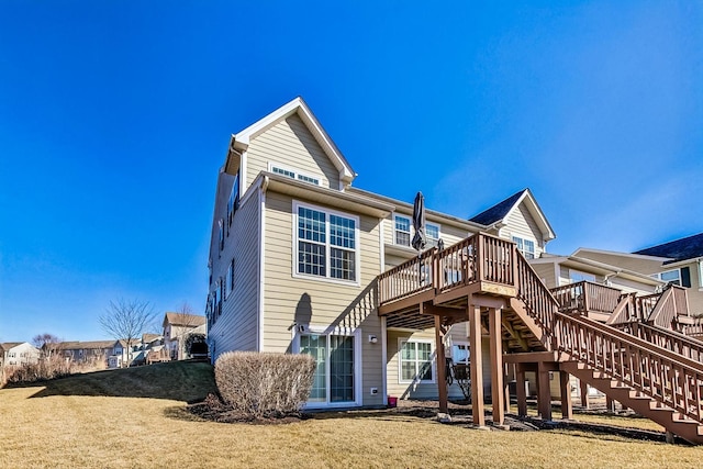 back of house featuring a lawn, a wooden deck, and stairs