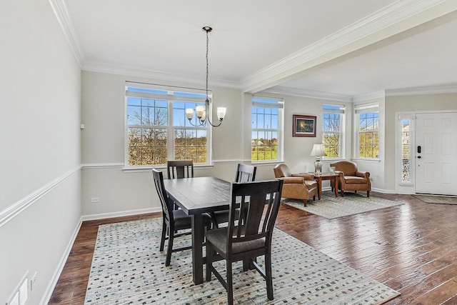 dining space with a chandelier, hardwood / wood-style flooring, visible vents, baseboards, and ornamental molding