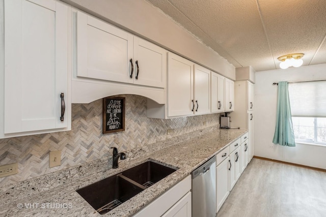 kitchen with a sink, decorative backsplash, white cabinets, and stainless steel dishwasher