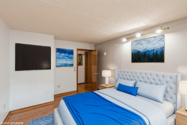 bedroom featuring baseboards and wood finished floors