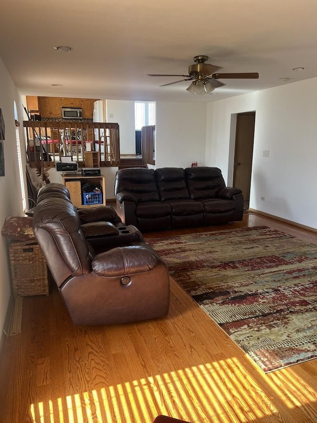 living area with ceiling fan, wood finished floors, and baseboards