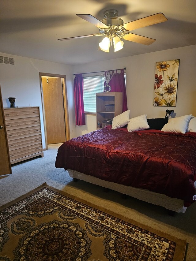 bedroom with carpet floors, visible vents, and a ceiling fan