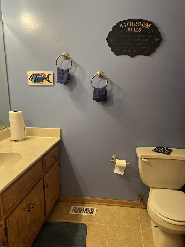 half bathroom featuring tile patterned flooring, visible vents, vanity, and toilet