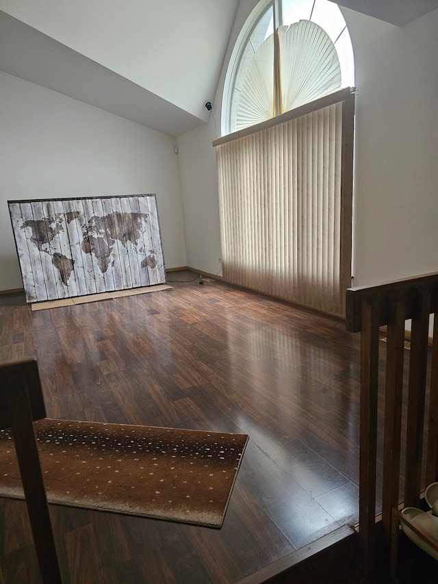 unfurnished living room with vaulted ceiling and wood finished floors