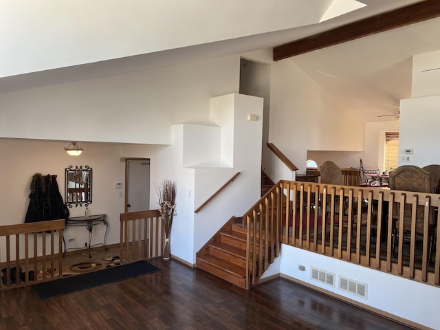 stairway featuring baseboards, ceiling fan, wood finished floors, high vaulted ceiling, and beam ceiling