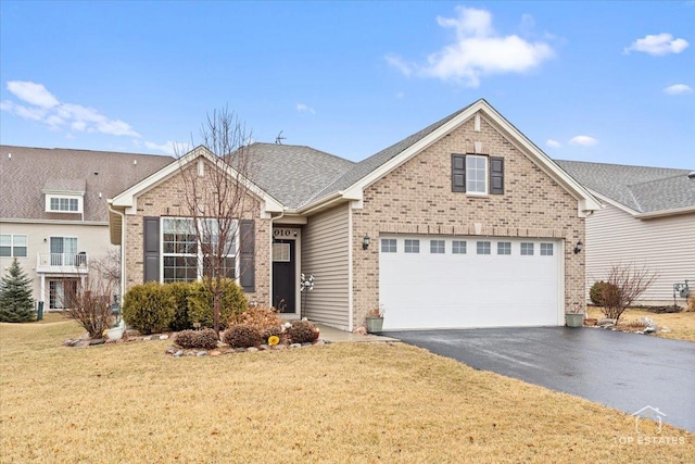 view of front of property featuring aphalt driveway, a front yard, brick siding, and a garage