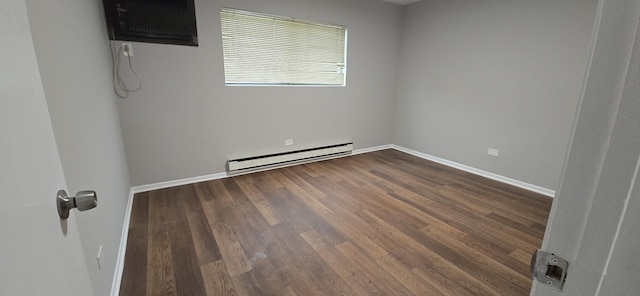 empty room featuring dark wood-type flooring, a baseboard radiator, a wall unit AC, and baseboards