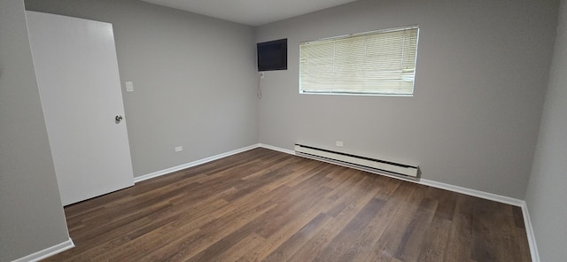 unfurnished room featuring baseboards, baseboard heating, and wood finished floors