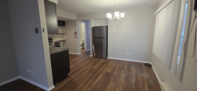 kitchen featuring baseboards, appliances with stainless steel finishes, dark wood-style flooring, light countertops, and a chandelier