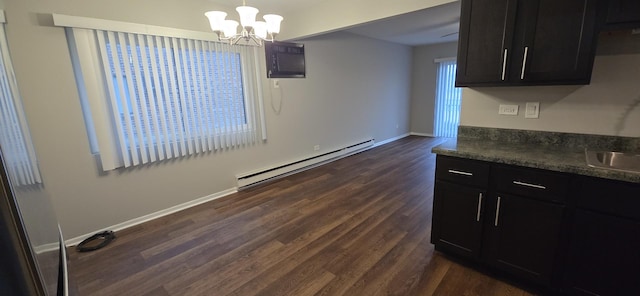 dining area featuring a wall unit AC, baseboard heating, dark wood-type flooring, a chandelier, and baseboards