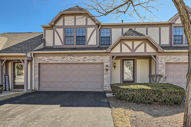 view of front of house with aphalt driveway, brick siding, and stucco siding