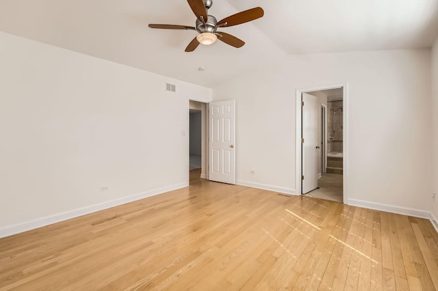 unfurnished bedroom with lofted ceiling, visible vents, light wood-style floors, connected bathroom, and baseboards