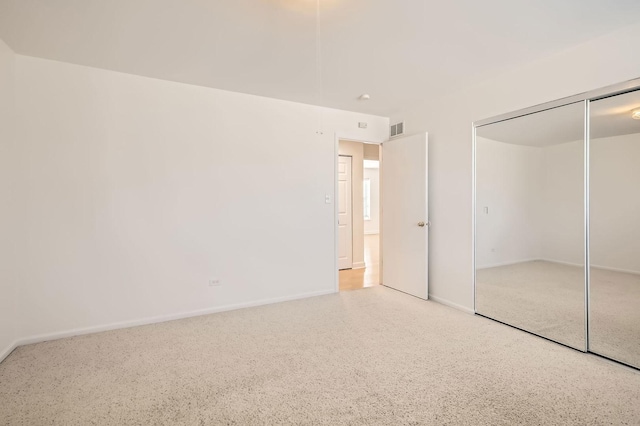 unfurnished bedroom with baseboards, visible vents, a closet, and speckled floor