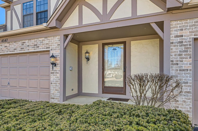 entrance to property featuring brick siding and stucco siding