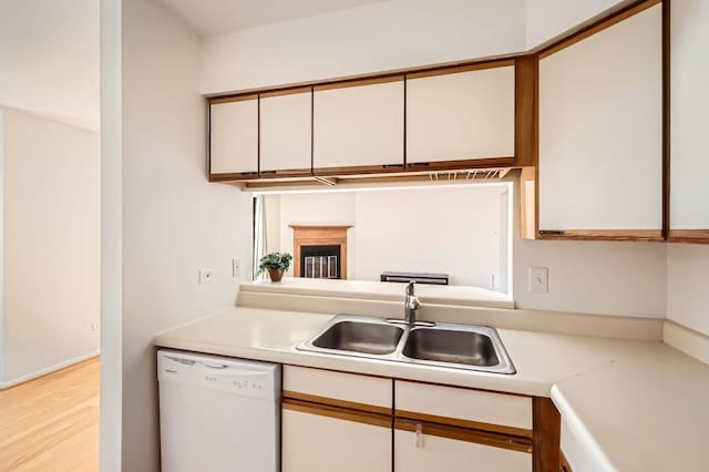 kitchen featuring a sink, white cabinetry, light countertops, and dishwasher