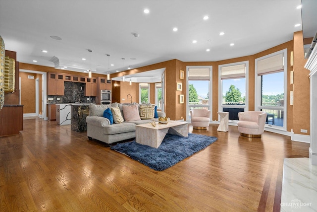 living area featuring dark wood-style floors, recessed lighting, a healthy amount of sunlight, and baseboards