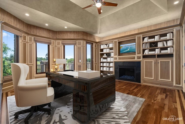 home office with a ceiling fan, a towering ceiling, dark wood-style floors, a fireplace, and recessed lighting