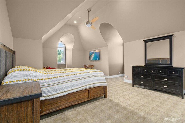 bedroom with light carpet, vaulted ceiling, and baseboards