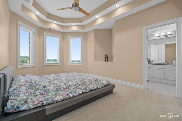 bedroom featuring recessed lighting, light colored carpet, connected bathroom, a sink, and baseboards