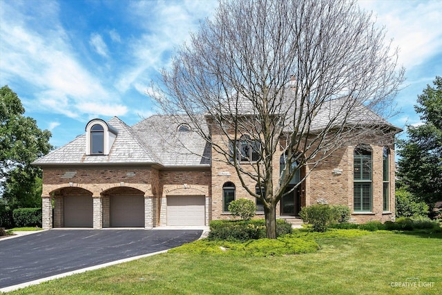 view of front of house with driveway, brick siding, a front lawn, and a high end roof