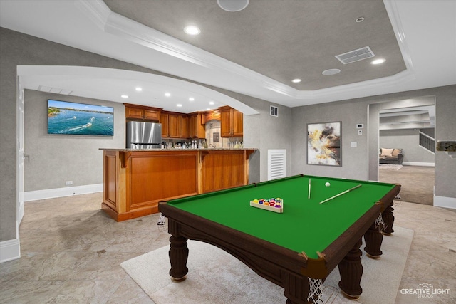 recreation room with visible vents, arched walkways, a raised ceiling, baseboards, and crown molding