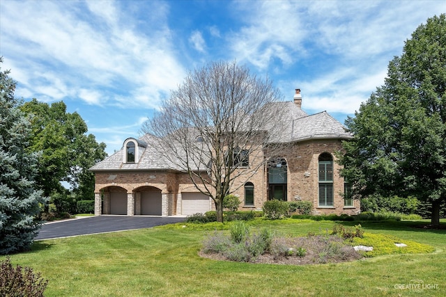 view of front of home featuring aphalt driveway, a high end roof, and a front lawn