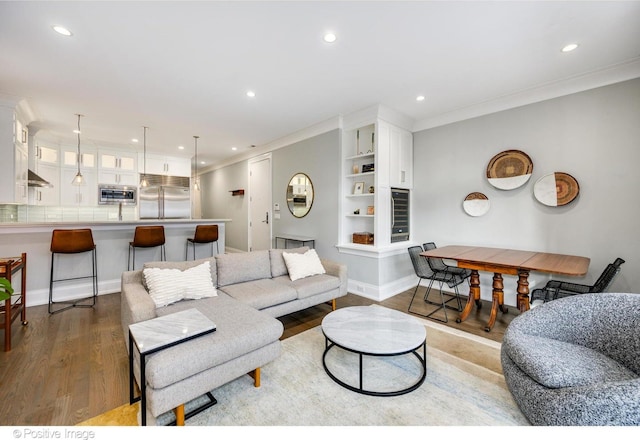 living room featuring recessed lighting, crown molding, baseboards, and wood finished floors