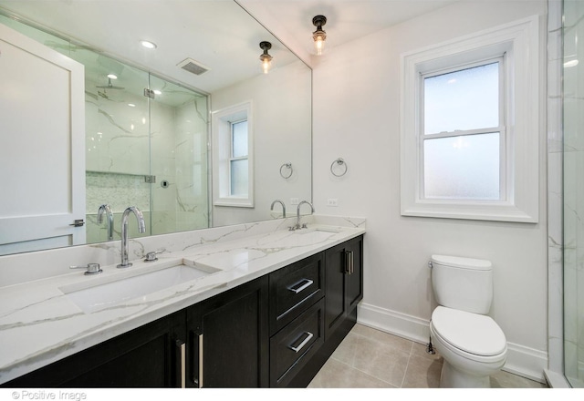 full bathroom featuring toilet, a marble finish shower, visible vents, and a sink