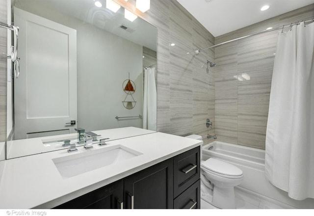 bathroom featuring visible vents, vanity, toilet, and shower / tub combo with curtain