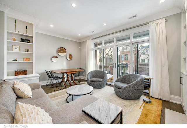 living area featuring recessed lighting, crown molding, baseboards, and wood finished floors