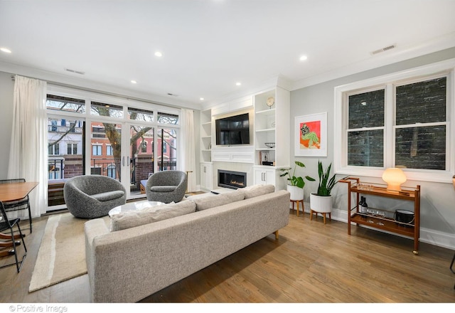 living room with french doors, recessed lighting, wood finished floors, a lit fireplace, and baseboards