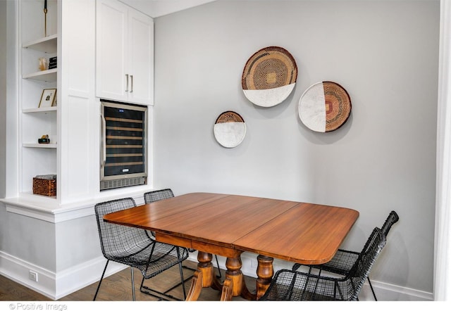 dining space with wine cooler, dark wood-type flooring, and baseboards