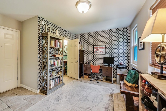 office space with wallpapered walls, light tile patterned flooring, baseboards, and an accent wall