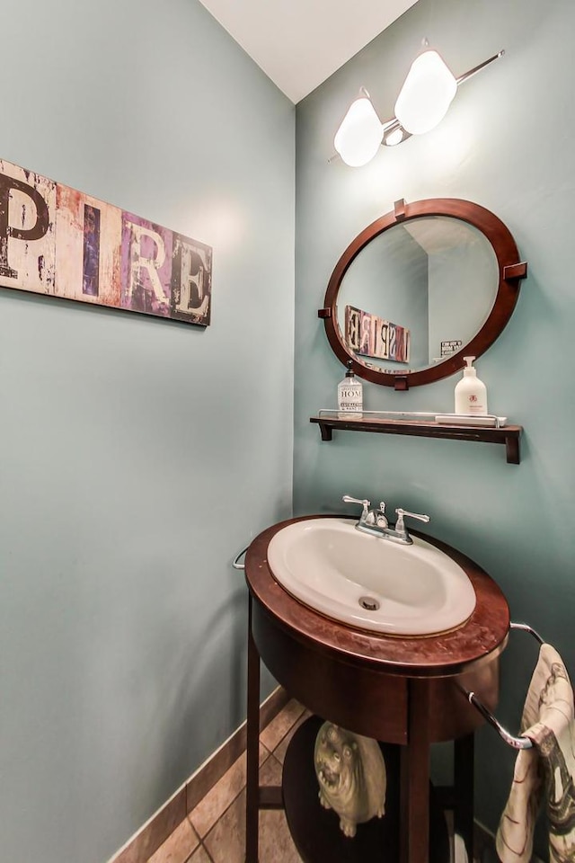 bathroom featuring tile patterned flooring, baseboards, and a sink