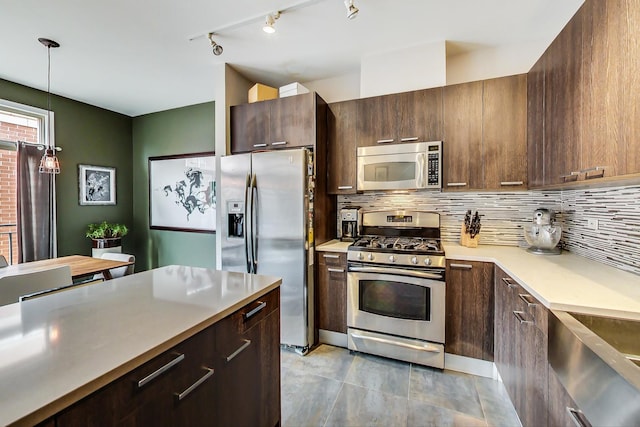 kitchen featuring tasteful backsplash, dark brown cabinets, decorative light fixtures, light countertops, and stainless steel appliances