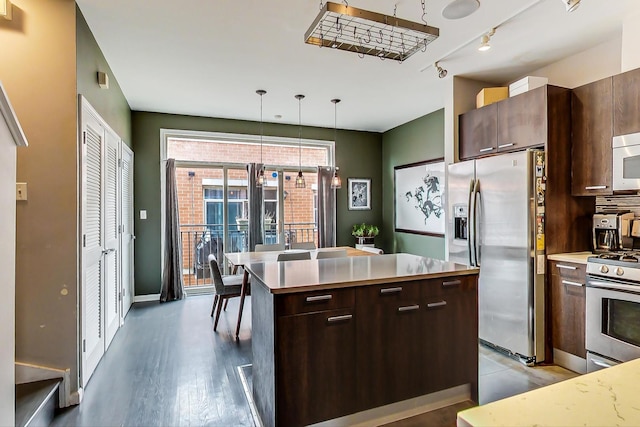 kitchen featuring modern cabinets, stainless steel appliances, dark brown cabinets, and light countertops