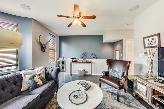 living room with a wealth of natural light, baseboards, a ceiling fan, and wood finished floors