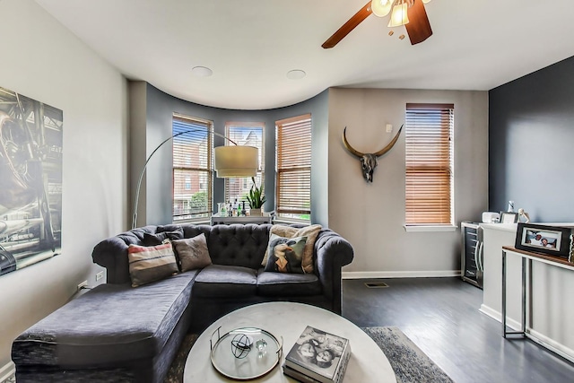 living area featuring baseboards, dark wood-style flooring, and ceiling fan