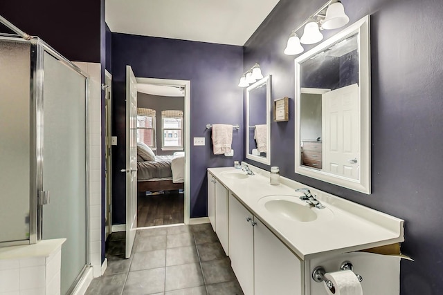 ensuite bathroom featuring tile patterned flooring, ensuite bath, a shower stall, and a sink