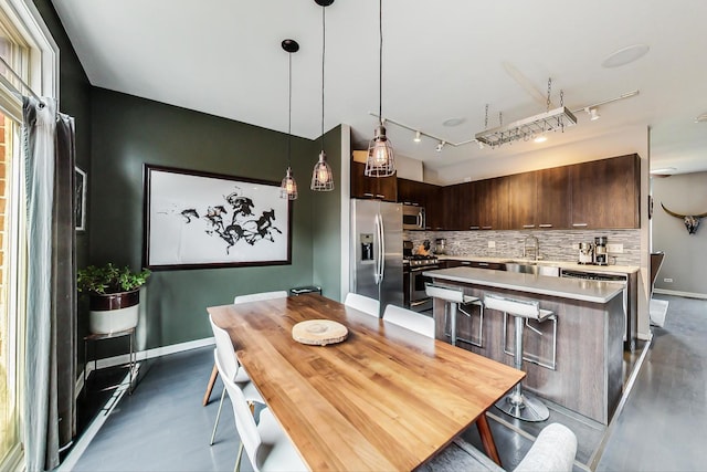 dining area with baseboards and rail lighting