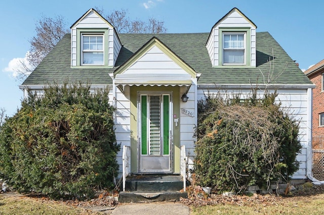 cape cod-style house with roof with shingles