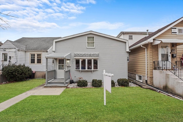 view of front of property with a front yard and roof with shingles