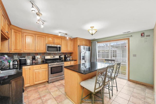 kitchen featuring stainless steel appliances, a breakfast bar, light tile patterned flooring, and a center island