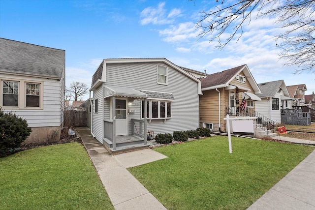 bungalow-style house with a front yard and fence