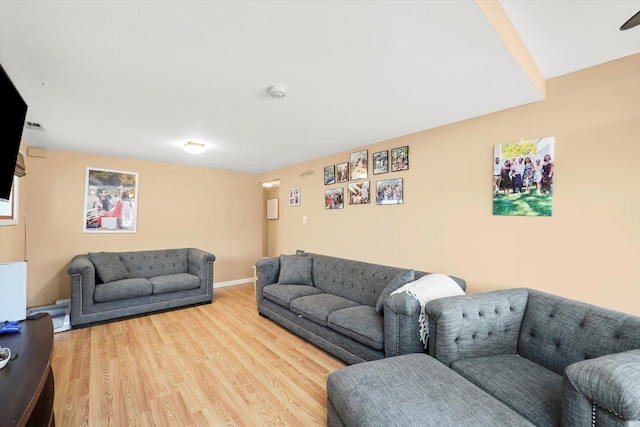 living area with baseboards and wood finished floors